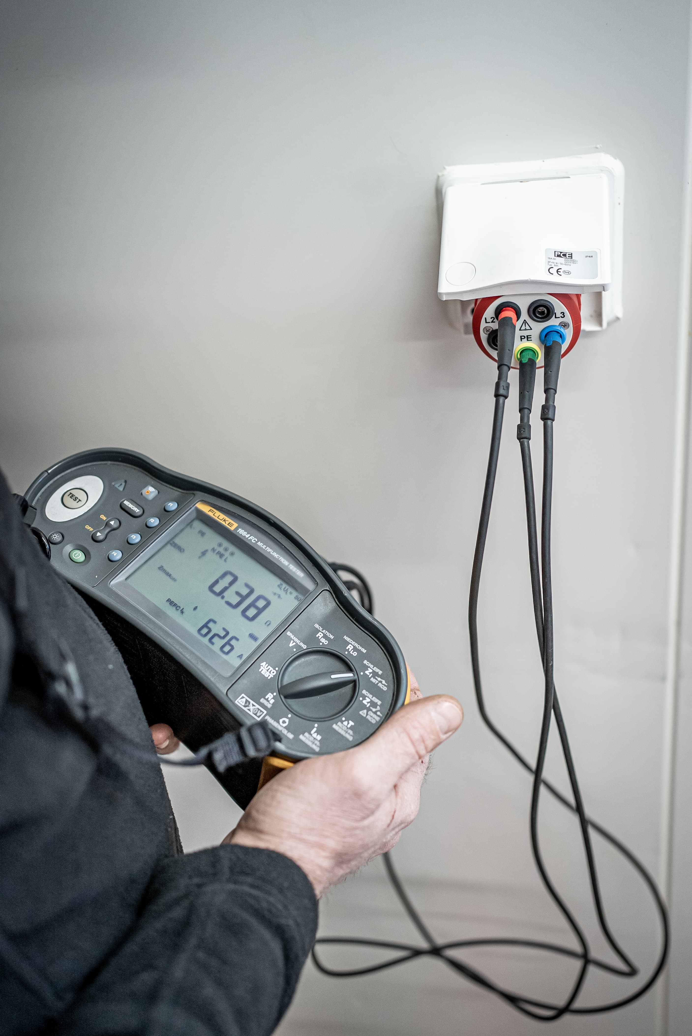 Elektrotechnische Sicherheitsprüfung mit Multifunktionstester an einer Steckdose